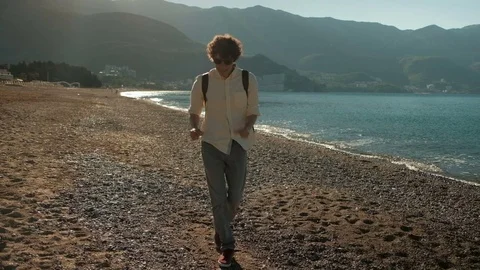 Young man dances on beach in summer day. Stock Footage 77493480