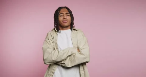 Young man dances in front of pink background while showcasing his style and.. Vídeos de archivo 326788247