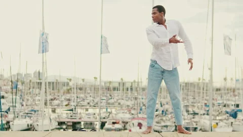 Young Man Dances Gracefully by the Marina Stock Footage 317569394