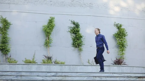 Young man dances walking past wall and trees slow motion Stock Footage 111278261