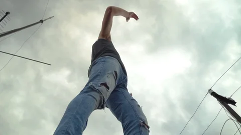 A young man dancing against the sky on the roof of a skyscraper. Stock Footage 116428485