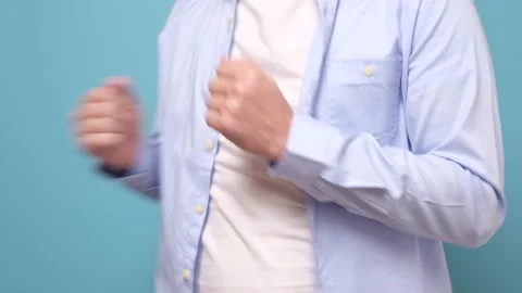 Young man dancing being happy on blue wall. Stock Footage 135544874