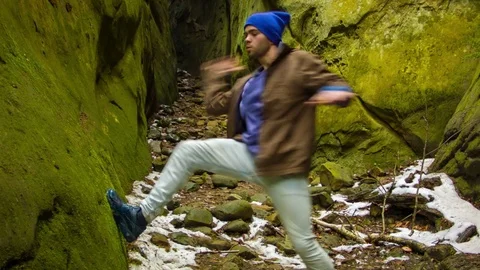 Young man dancing in the canyon Stock Footage 82547252