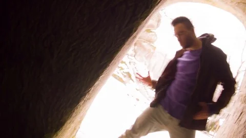 Young man dancing in the cave doorway 스톡 동영상 82453890