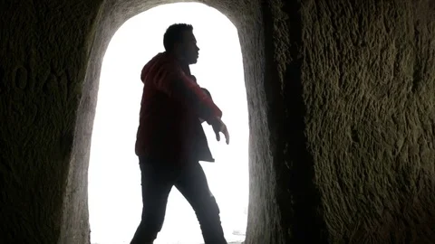 Young man dancing in the cave doorway 動画素材 82588128