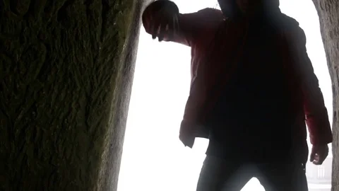 Young man dancing in the cave doorway Video stock 82588825
