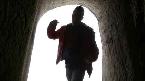 Young man dancing in the cave doorway Vídeos de archivo 82589551