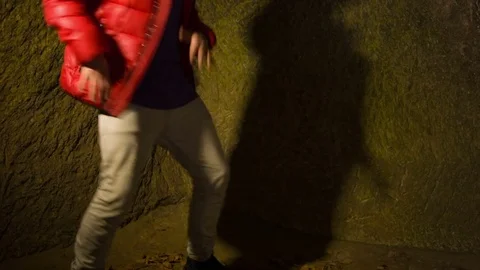 Young man dancing in the cave. Video stock 82462515