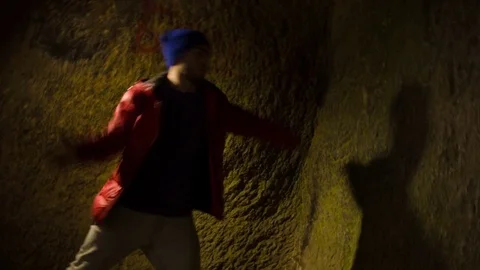 Young man dancing in the cave. Vídeo Stock 82486567