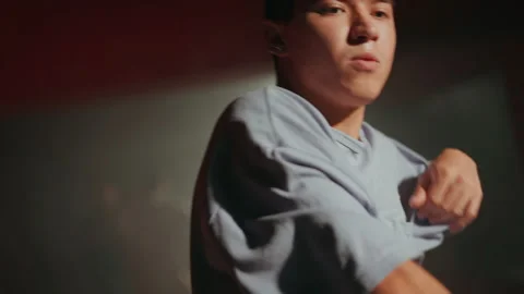 Young man dancing contemporary hip hop on white light background in studio Stock Footage 253576827