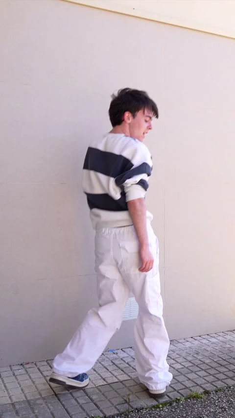Young man dancing freestyle urban style against wall Stock Footage 303335431