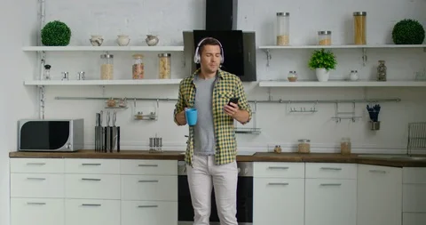 Young man is dancing in his new kitchen Stock Footage 113231377