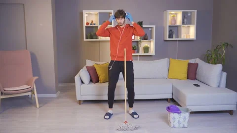 Young man dancing at home, turning on music from music app on his smartphone  Stock Footage 222518697