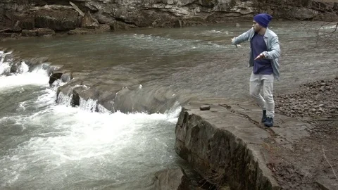 Young man dancing near a river in the mountains Stock-Footage 82611274