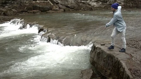 Young man dancing near a river in the mountains Stock Footage 82613970