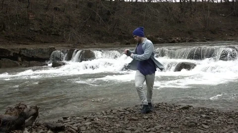 Young man dancing near a river in the mountains Vídeos de archivo 82629668