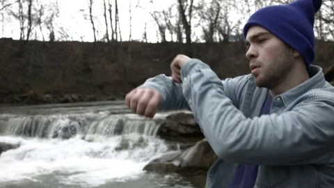 Young man dancing near a river in the mountains 動画素材 82630543