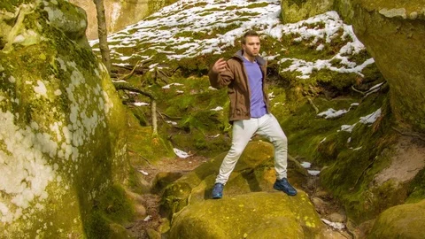 Young man dancing on a rock Vídeo Stock 81231692