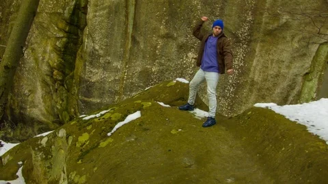 Young man dancing on a rock Video stock 82416684
