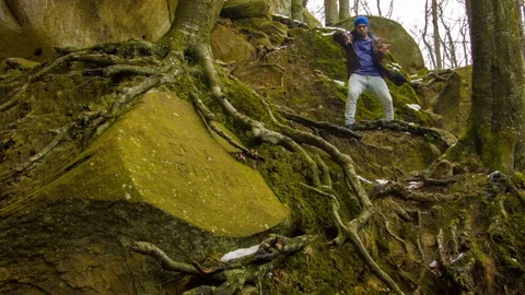 Young man dancing on a rock Stockbeeldmateriaal 82524963