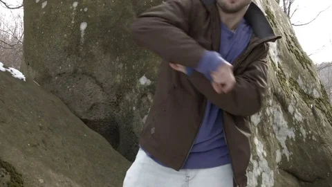 Young man dancing on a rock in the mountains. Vídeo Stock 82662830