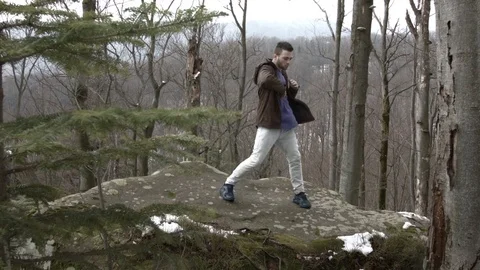 Young man dancing on a rock in the mountains. Stock Footage 82665292