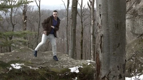 Young man dancing on a rock in the mountains. Stock-Footage 82666692
