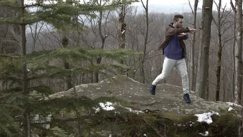 Young man dancing on a rock in the mountains. 스톡 동영상 82668459
