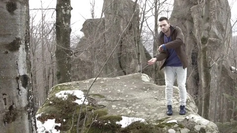 Young man dancing on a rock in the mountains. Vídeos de archivo 82692052