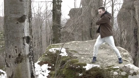 Young man dancing on a rock in the mountains. 스톡 동영상 82699628