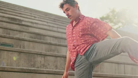 Young Man Dancing on Steps in Sunlight Stock Footage 322998809