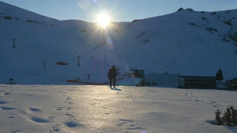 Young man in dark clothes walking slowly up the snowy mountain Stock Footage 106477393