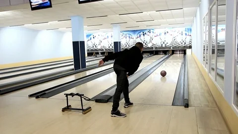 Young man in a dark suit throws bowling ball in lane bowling Stock Footage 114137472