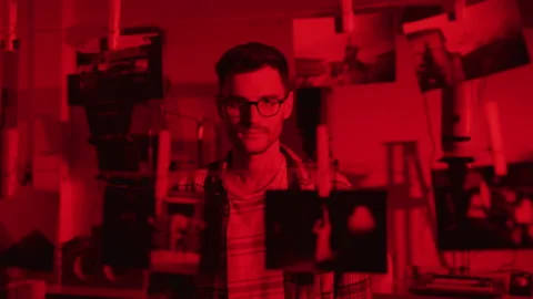 Young man in a darkroom Stock Footage 214929358