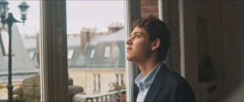 Young man daydreaming by the window Stock Footage 203586078