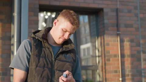 Young man decides to quit smoking and throws cigarette away outside building Video stock 307067704