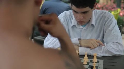 Young Man Deep in Thought Playing Chess Outdoors Stock Footage 341323660