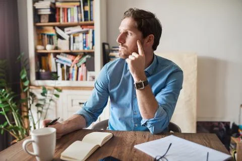 Young man deep in thought while working from home Foto stock