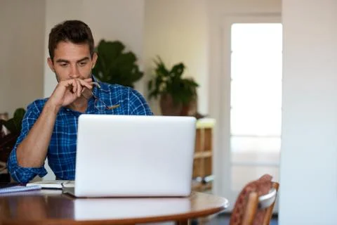 Young man deep in thought while working remotely from home Stock Photos