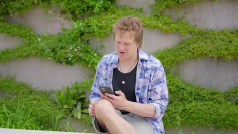 A young man deeply engaged with evolving technology while in a peaceful natural Stock Footage 282211096