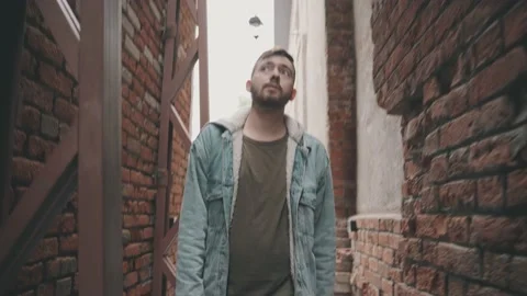 Young man in denim jacket walks through the vintage tunnel 库存影片 144979966