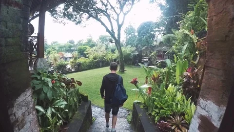 A young man descends an authentic staircase in a temple on a tropical island Stock Footage 88383530