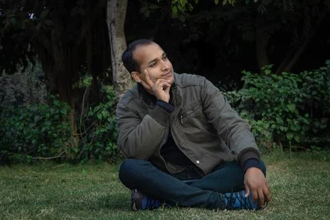 Young man different moods of expression cross leg sitting in a park from flat Stock Photos