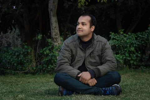 Young man different moods of expression cross leg sitting in a park from flat Foto stock
