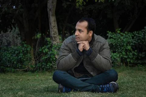 Young man different moods of expression cross leg sitting in a park from flat Foto stock