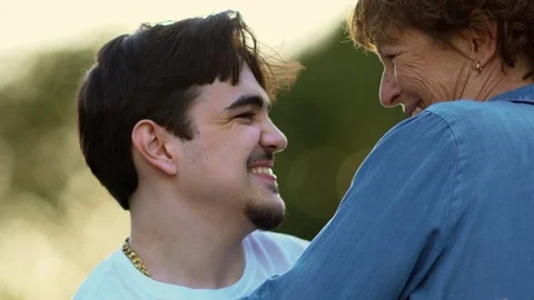Young man with a disability hugging his carer. 스톡 동영상 88374966