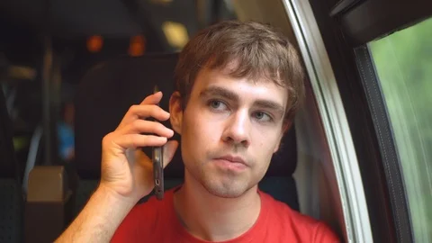 Young man discussing seriously on smart phone inside moving train - Released Stock Footage 93123304