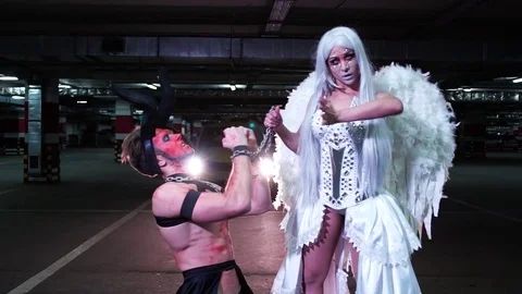 Young man in disguise of the devil Halloween dancing with freaky girl in the 動画素材 70872638