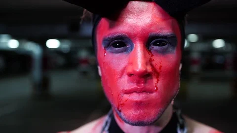 Young man in disguise of the devil Halloween dancing in the underground parking 動画素材 70873489