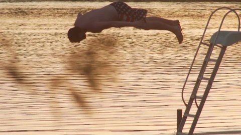 Young Man Dives off Floating Platform Beautiful Evening Angle 2 Stock Footage 87043018